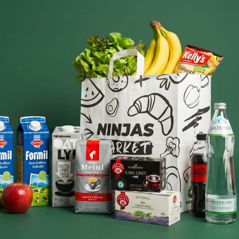 Ninjas.jetzt Einkaufstüte aus Papier, voll mit Lebensmitteln und Produkten, auch drumherum.